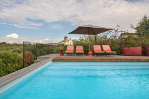 a swimming pool with two chairs and an umbrella at Casa Dr Ramiro Salgado - Douro Superior, Torre de Moncorvo in Torre de Moncorvo +55 photos