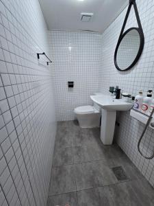 a white tiled bathroom with a sink and a toilet at a 모텔 in Seoul
