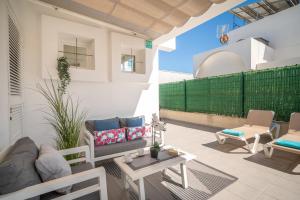 a living room with a couch and chairs on a patio at Villa Savina by BeBreeze in Can Picafort