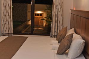 a bedroom with a bed with pillows and a window at Villa Sanchana in Galle