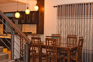 a dining room with a wooden table and chairs at Villa Sanchana in Galle