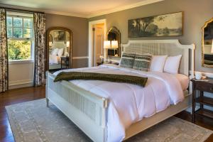 a bedroom with a large bed with a large white bedspread at Bohemia Manor Farm in Chesapeake City