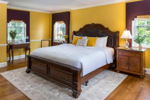 a bedroom with a large bed and yellow walls at Bohemia Manor Farm in Chesapeake City