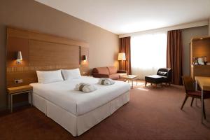 a hotel room with a large white bed and a desk at Mercure Ostrava Center in Ostrava +79 photos