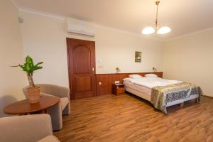 a bedroom with a bed and a table and a couch at Private Vendégház in Villány