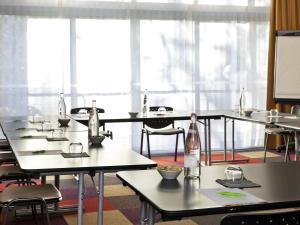 a room with tables and chairs with bottles on them at ibis Styles Antibes in Antibes