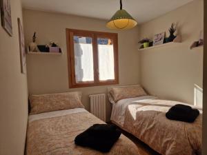 a bedroom with two beds and a window at VALDI-BIESCAS in Biescas