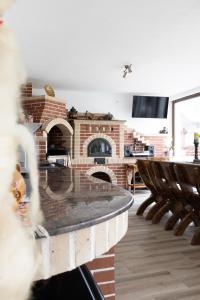 a living room with a brick fireplace and a table and chairs at Seren Natura Retreat in Sebeşu de Sus