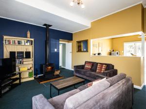 a living room with a couch and a fireplace at Oroua Cottage - Rangataua Bach in Ohakune