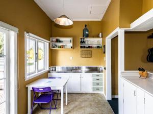 a kitchen with a white table and purple chairs at Oroua Cottage - Rangataua Bach in Ohakune