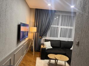 a living room with a black couch and a table at Inza in Druskininkai