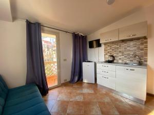 a kitchen with a blue couch and a kitchen with a window at Tao House in Taormina +32 photos