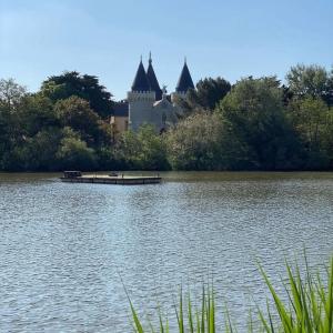 a castle sitting on the side of a lake at Ma maison près du golf in Talmont