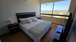 a bedroom with a bed and a large window at La PERLA DEL MORRO in Porlamar +38 photos