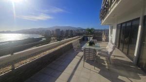 a balcony with chairs and a view of the ocean at La PERLA DEL MORRO in Porlamar