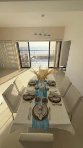 a dining room table with a white table with chairs and a table at La PERLA DEL MORRO in Porlamar