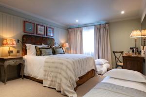 a bedroom with a large bed and a window at The Potters Heron - A Heartwood Inn in Romsey
