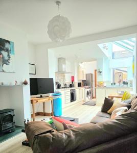 a living room with a couch and a kitchen at Orebank Cottage in Millom