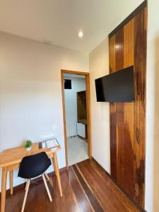 a room with a desk and a chair and a television at Econteiner Hotel Juruti in Juruti