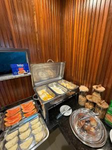 a buffet with trays of food on a table at Econteiner Hotel Juruti in Juruti