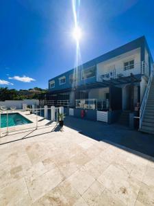 a large blue house with a swimming pool at Over The Hill Residence - Your Tranquil Oasis in Grand Case