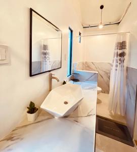 a bathroom with a sink and a mirror at KAMURAYAW SIARGAO in General Luna +55 photos