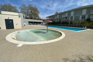a small swimming pool with an umbrella in the middle at Air-conditioned house in the Arcachon style with swimming pool in La Teste-de-Buch