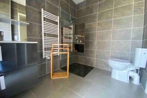 a bathroom with a toilet and a window in it at Air-conditioned house in the Arcachon style with swimming pool in La Teste-de-Buch +7 photos