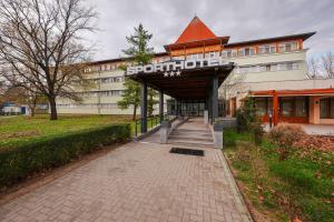 a building with a sign on the front of it at Sport Hotel in Debrecen