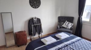 a bedroom with a suit hanging on a wall at L'Indus -HyperCentre-WIFI-2à4pers in Saint-Nazaire