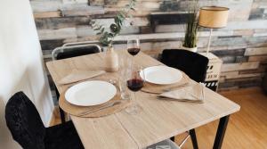 a wooden table with plates and glasses of wine at L'Indus -HyperCentre-WIFI-2à4pers in Saint-Nazaire