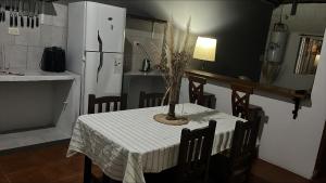 a dining room table with a white table cloth and a refrigerator at La martinez in San Antonio de Areco