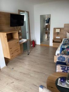 a living room with a bed and a tv in it at Hotel Falkenseer Hof in Falkensee +6 photos