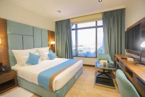 a hotel room with a bed and a desk and a computer at Madareem Hotel in Riyadh +109 photos