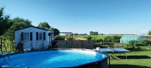 a large swimming pool in a yard with a house at Chez Elvis et Agnès, logement climatisé in Saint-Loup