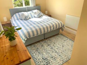 a bedroom with a bed with a blue and white comforter at La Mer self-catering in Sark