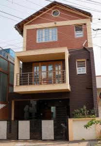 a house with a balcony on the side of it at DUDI's Stay in Mysore
