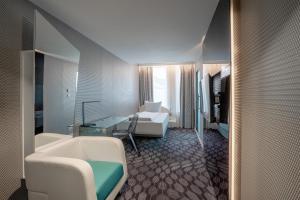 a hotel room with a bathroom with a bed and a sink at Prize by Radisson, Xhibition Bergen City in Bergen
