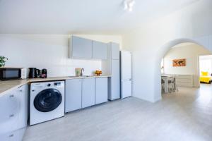 a white kitchen with a washer and dryer at Casa do Vale in Paderne