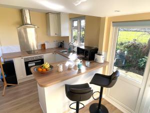 a kitchen with a counter with a bowl of fruit on it at La Mer self-catering in Sark