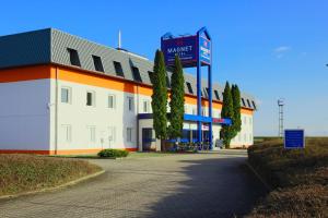 a large building with a sign in front of it at Magnet Hotel in Schkeuditz