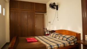 a bedroom with a bed with two red pillows on it at DUDI's Stay in Mysore