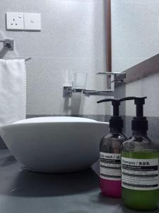 a bathroom with a sink and two bottles of soap at Niwasa Habarana in Habarana