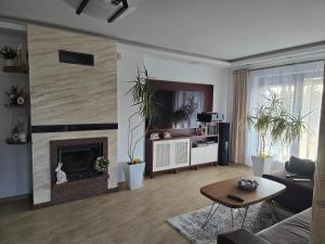 a living room with a fireplace and a table at Białowieski Raj in Białowieża