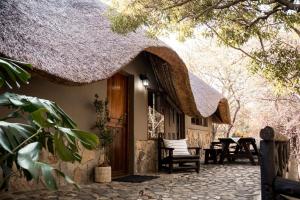a house with a thatched roof and a patio at LittleBush Private Lodge in Hoedspruit