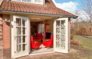 an extension of a house with red chairs on a patio at Buitengoed Het Lageveld - 65 in Hoge-Hexel