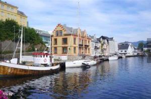 a group of boats docked in a river with buildings at Penthouse in Farsund in Farsund