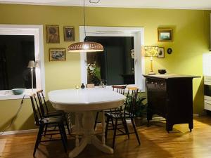 a dining room with a white table and chairs at Penthouse in Farsund in Farsund