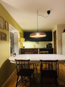 a kitchen with a large white table and chairs at Penthouse in Farsund in Farsund +20 photos