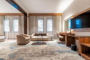 a living room with a couch and a table and chairs at Madareem Hotel in Riyadh